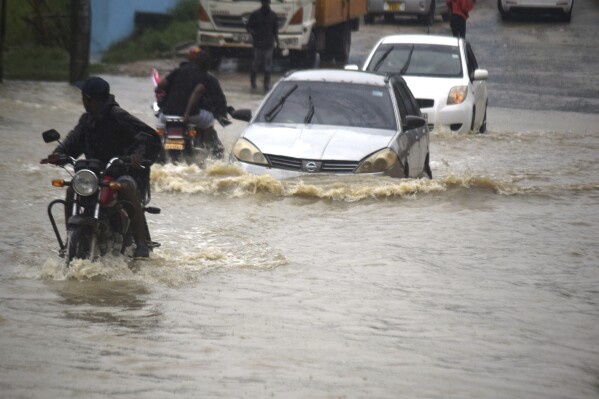 Motorists wade through a flooded road in Mombasa town after a heavy downpour on Friday Nov.3, 2023. Most of the roads remained impassable due to poor drainage system within the town. (AP Photo/Gideon Maundu).