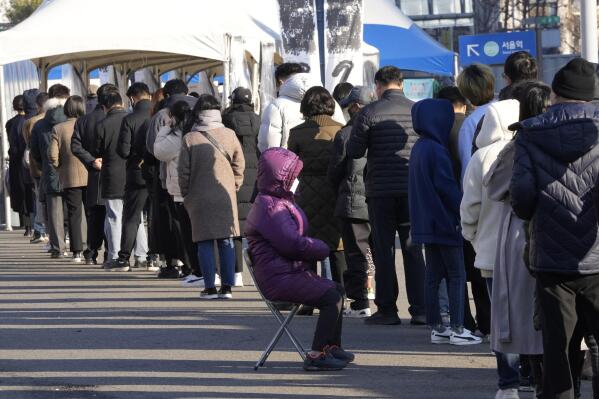 People queue in line to wait for the coronavirus testing at a makeshift testing site in Seoul, South Korea, Wednesday, Dec. 8, 2021. (AP Photo/Ahn Young-joon).