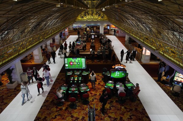 People walk through the casino floor at the Tropicana hotel-casino Friday, March 29, 2024, in Las Vegas. The property is scheduled to close April 2, 2024. (AP Photo/John Locher)