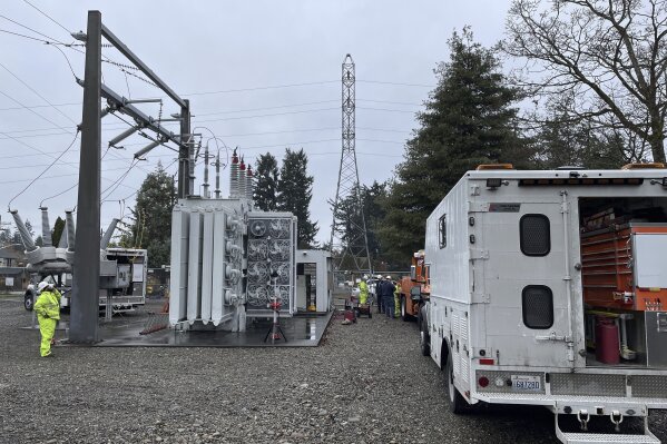 FILE- A Tacoma Power crew works at an electrical substation damaged by vandals early on Christmas morning after cutting a padlock to gain entry, according to a crew manager, Dec. 25, 2022, in Graham, Wash. Two men pleaded guilty to vandalizing power substations in Washington state in attacks that left thousands without power on Christmas Day. Jeremy Crahan admitted Wednesday, Sept. 6, 2023, that he and Matthew Greenwood, who pleaded guilty in April to conspiracy to destroy energy facilities, conspired to cut electrical power in order to break into ATM machines and businesses and steal money. (Ken Lambert/The Seattle Times via AP, File)