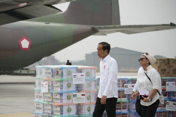 Indonesian President Joko Widodo, left, and Foreign Minister Retno Marsudi inspect the relief supplies for Palestinians in Gaza, before its departure at Halim Perdanakusuma air base in Jakarta, Indonesia, Saturday, Nov. 4, 2023. (AP Photo/Achmad Ibrahim)