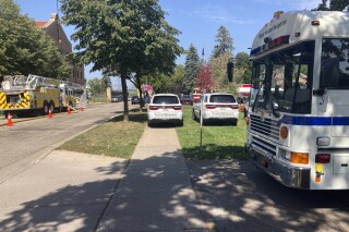 A fleet of emergency vehicles sit parked outside of Minnesota Correctional Facility-Stillwater prison in Bayport, Minn., on Sunday, Sept. 3, 2023. The prison was placed on emergency lockdown after about 100 inmates in a housing unit facing dangerously high heat would not return to their cells. (David Boehnke via AP)