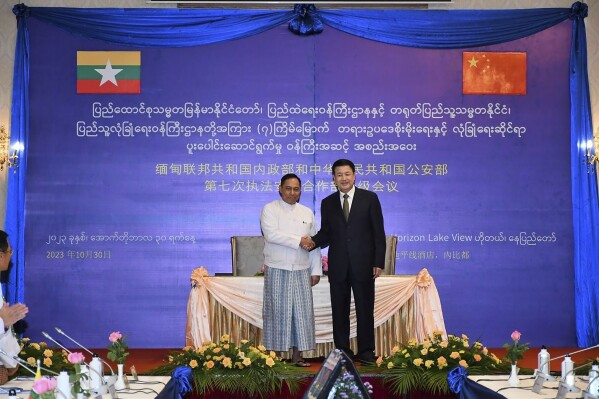 In this photo released from the The Military True News Information Team on Oct.30, 2023, Lt-Gen Yar Pyae, left, State Administration Council Member and Home Affair Minister, shakes hands with Wang Xiaohong, right, Chinese Minister for public security, during their meeting in Naypyitaw, Myanmar. (The Military True News Information Team via AP)