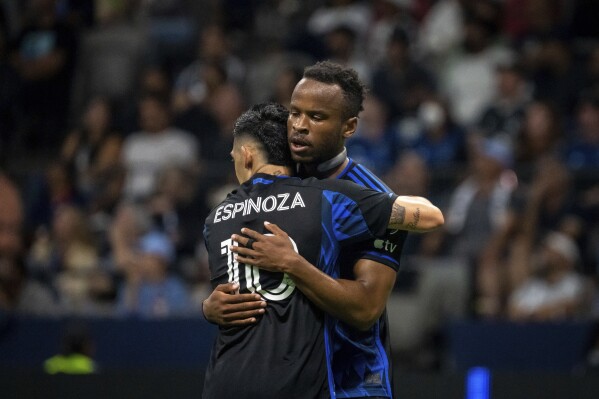 San Jose Earthquakes' Jeremy Ebobisse, right, and Cristian Espinoza (10) celebrate after Espinoza scored a goal against the Vancouver Whitecaps during first-half MLS soccer match action in Vancouver, British Columbia, Sunday, Aug. 20, 2023. (Ethan Cairns/The Canadian Press via AP)