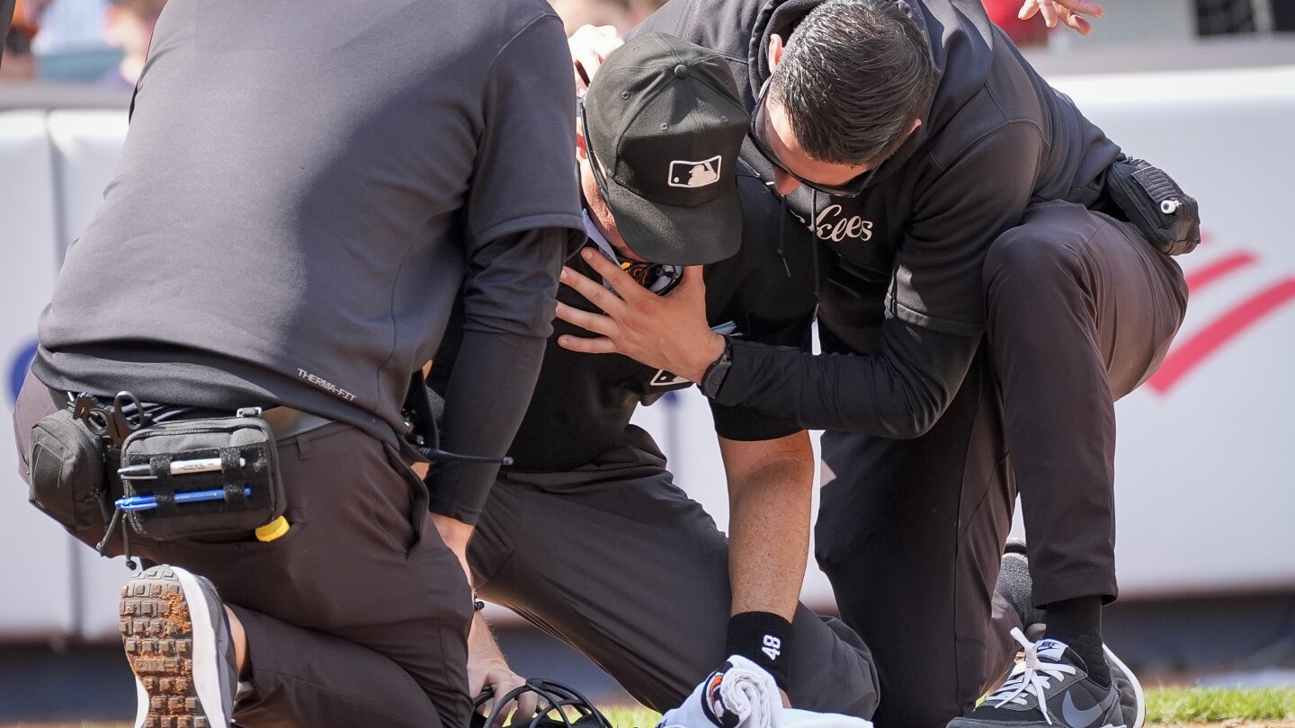 Umpire Nick Marley is ejected from the game between the Rockies and Yankees after being hit in the neck by a broken bat.