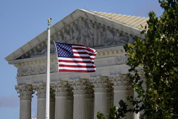 FILE - An American flag blows in the wind in front of the Supreme Court building on Capitol Hill in Washington, Nov. 2, 2020. (AP Photo/Patrick Semansky, File)