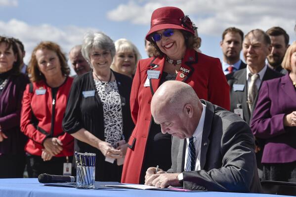 FILE - Republican Gov. Greg Gianforte signs one of three bills restricting access to abortion in Montana as sponsor of one of the bills, state Rep. Lola Sheldon-Galloway, R-Great Falls, watches in Helena, Mont., on April 26, 2021. Planned Parenthood of Montana filed a preemptive lawsuit Monday, April 10, 2023, seeking to stop legislation that would ban the abortion method most commonly used in the second trimester, arguing it's unconstitutional. (Thom Bridge/Independent Record via AP, File)