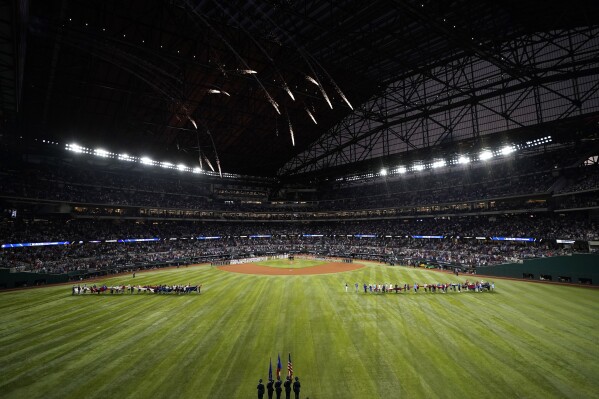The Houston Astros and Texas Rangers line up before Game 3 of the baseball American League Championship Series Wednesday, Oct. 18, 2023, in Arlington, Texas. (AP Photo/Tony Gutierrez)