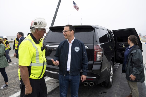 Gov. Josh Shapiro, right, talks with Robert Buckley, president Buckley & Co. during a news conference to announce the reopening of Interstate 95 Friday, June 23, 2023 in Philadelphia. Workers put the finishing touches on an interim six-lane roadway that will serve motorists during construction of a permanent bridge. (AP Photo/Joe Lamberti)