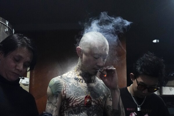 A Chinese punk rocker smokes a cigarette as he waits backstage during a punk festival in Hangzhou, China, Friday, Jan. 17, 2025. (AP Photo/Aaron Favila)