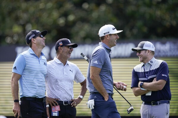 FILE - NBC on-course reporter John Wood, right, Dustin Johnson, second from right, Claude Harman, second from left and caddie Austin Johnson share a laugh during practice for the Tour Championship on Sept. 1, 2021, at East Lake Golf Club in Atlanta. Wood, a former caddie, has been appointed Ryder Cup team manager for the Americans.(AP Photo/Brynn Anderson, File)
