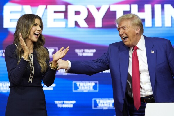President Donald Trump stands with Kristi Noem during a town hall at the Greater Philadelphia Expo Center &amp; Fairgrounds, Oct. 14, 2024. (AP Photo/Alex Brandon, File)