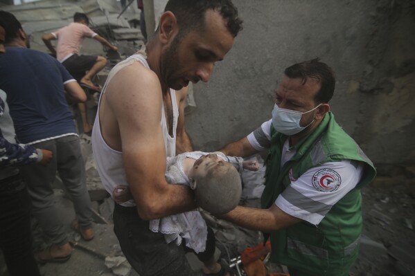 Palestinian medic takes a baby pulled out of buildings destroyed in the Israeli bombardment of the Gaza Strip in Rafah, Sunday, Oct. 22, 2023. (AP Photo/Hatem Ali)