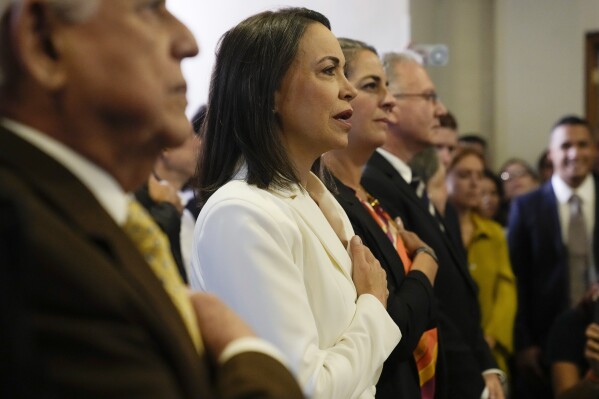 FILE - Maria Corina Machado joins in the singing of the Venezuelan national anthem during a ceremony with the Opposition Primary Commission to recognize her electoral win in the opposition-organized primary election to choose a presidential candidate to face President Nicolas Maduro, in Caracas, Venezuela, Oct. 26, 2023. The Comptroller General's Office disqualified Machado from holding public office for 15 years just a few months before the primaries in which she was victorious with popular support of 92.35%. (AP Photo/Ariana Cubillos, File)