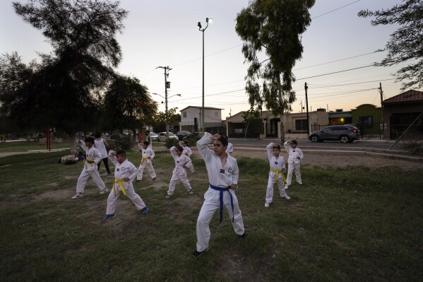 Children take part in a Taekwondo class after the sun set on a day of temperatures beyond 115 degrees Fahrenheit, July 19, 2023, in Mexicali, Mexico. (AP Photo/Gregory Bull)