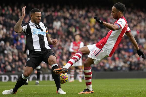Newcastle's Jamaal Lascelles, left, duels for the ball with Arsenal's Pierre-Emerick Aubameyang during the English Premier League soccer match between Arsenal and Newcastle United at Emirates stadium in London, Saturday, Nov. 27, 2021. (AP Photo/Kirsty Wigglesworth)