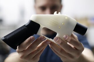 
              FILE - In this Aug. 1, 2018, file photo, Cody Wilson, with Defense Distributed, holds a 3D-printed gun called the Liberator at his shop in Austin, Texas. A federal judge in Seattle has granted an injunction that prohibits the Trump administration from allowing a Texas company to post 3D gun-making plans online. (AP Photo/Eric Gay, file)
            
