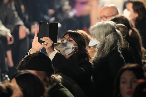 FILE - In this Feb. 27, 2020 file photo, spectators wear protective masks during the Isabel Marant fashion collection during Women's fashion week Fall/Winter 2020/21 presented in Paris. The coronavirus pandemic has instilled extra unpredictability into the already fickle Paris Fashion Week. After first canceling the July shows for menswear and Haute Couture, the French fashion federation has now organized an unprecedented schedule of digital-only events instead. (AP Photo/Michel Euler, File)