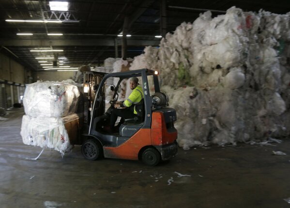 
              In this May 7, 2019 photo, a forklift moves through stacks of recyclables at a GDB International warehouse in Monmouth Junction, N.J. GDB International exported bales of scrap plastic film such as pallet wrap and grocery bags for years. But when China started restricting imports, company president Sunil Bagaria installed new machinery to process it into pellets he sells profitably to manufacturers of garbage bags and plastic pipe. (AP Photo/Seth Wenig)
            