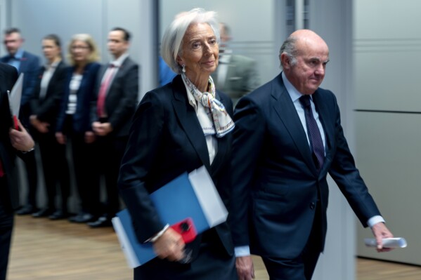 President of European Central Bank Christine Lagarde, center, walks to the press conference in Frankfurt, Germany, Thursday, March 7, 2024, after a meeting of the ECB's governing council. The European Central Bank left its key interest rate at a record high as it waits for more confirmation that toxic inflation is under control for good — even as high borrowing costs drag on the stalled economy. (AP Photo/Michael Probst)