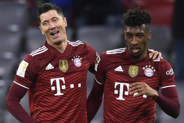 Bayern's Robert Lewandowski, left, celebrates with Bayern's Kingsley Coman after scoring his side's second goal during a German Bundesliga soccer match between Bayern Munich and Leipzig at the Allianz Arena in Munich, Germany, Saturday, Feb. 5, 2022. (AP Photo/Andreas Schaad)