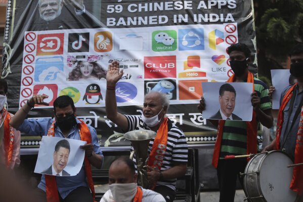 FILE- Activists of Jammu and Kashmir Dogra Front shout slogans against Chinese President Xi Jinping next to a banner showing the logos of TikTok and other Chinese apps banned in India during a protest in Jammu, India, July 1, 2020. (Ǻ Photo/Channi Anand, File)