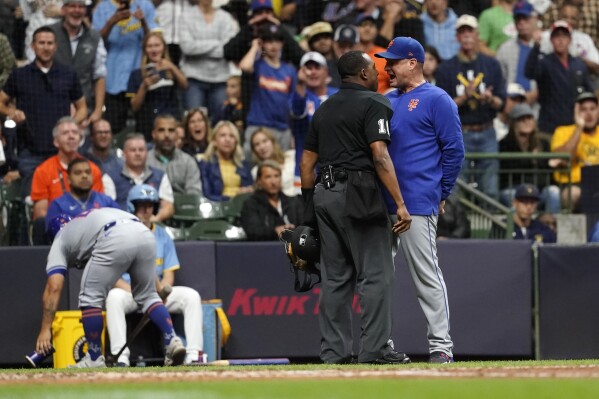 New York Mets manager Carlos Mendoza, right, yells to umpire Ramon De Jesus, second from right, after being ejected during the fourth inning of a baseball game against the Milwaukee Brewers, Friday, Sept. 27, 2024, in Milwaukee. (AP Photo/Aaron Gash)