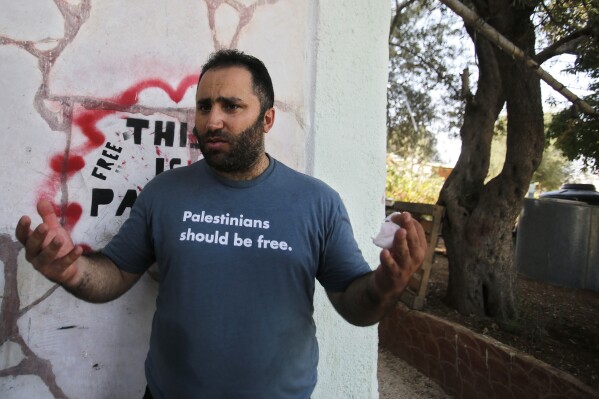 FILE - In this Sept. 10, 2017 file photo, prominent Palestinian activist Issa Amro speaks after his release from detention, in the West Bank city of Hebron. Israeli troops expelled the prominent Palestinian activist from his home in a West Bank city at the heart of the Israeli-Palestinian conflict, after he hosted a foreign journalist and a well-known Israeli activist. Critics accused the military of using the cover of the Israel-Hamas war to expel Issa Amro from volatile Hebron, the only city in the West Bank where Jewish settlers live among Palestinians. (AP Photo/Nasser Shiyoukhi, File)