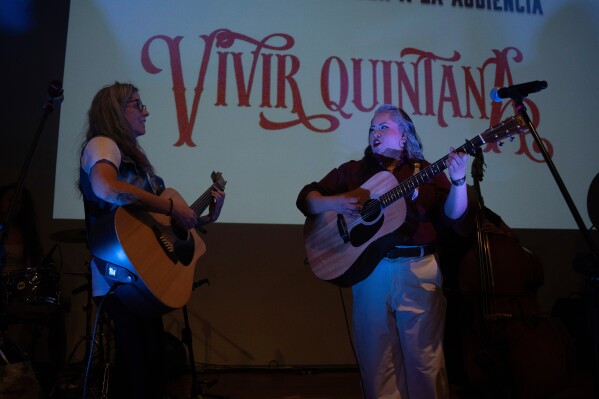 Mexican singer Vivir Quintana, right, performs songs from her new album “Cosas que Sorprenden a la Audiencia” or Things that Surprise the Audience, in Mexico City, Thursday, April 24, 2025. Her first "corridos" album tells the stories of women who were incarcerated for killing their abusers while defending themselves. (AP Photo/Aurea Del Rosario)
