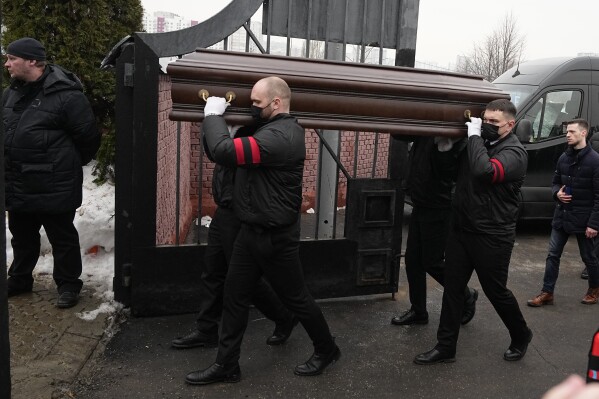 A coffin of Russian opposition leader Alexei Navalny is carried to the entrance of the Borisovskoye Cemetery during the funeral ceremony, in Moscow, Russia, Friday, March 1, 2024. Under a heavy police presence, thousands of people bade farewell Friday to Alexei Navalny at his funeral in Moscow after his still-unexplained death two weeks ago in an Arctic penal colony. (AP Photo)