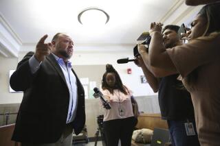 Alex Jones talks to media during a midday break during the trial at the Travis County Courthouse in Austin, Texas, Tuesday, July 26, 2022. An attorney for the parents of one of the children who were killed in the Sandy Hook Elementary School shooting told jurors that Jones repeatedly “lied and attacked the parents of murdered children” when he told his Infowars audience that the 2012 attack was a hoax. Attorney Mark Bankston said during his opening statement to determine damages against Jones that Jones created a “massive campaign of lies” and recruited “wild extremists from the fringes of the internet ... who were as cruel as Mr. Jones wanted them to be" to the victims' families. Jones later blasted the case, calling it a “show trial” and an assault on the First Amendment. (Briana Sanchez/Austin American-Statesman via AP, Pool)