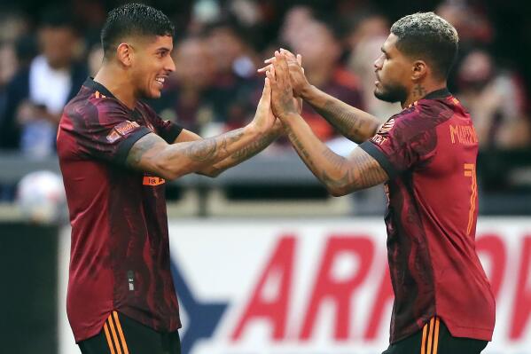 Atlanta United forward Josef Martinez, right, gets a double high-five from Alan Franco after scoring the only goal of the match against Los Angeles FC in the second half of an MLS soccer match on Sunday, Aug. 15, 2021, in Atlanta. Atlanta United won 1-0. (Curtis Compton/Atlanta Journal-Constitution via AP)