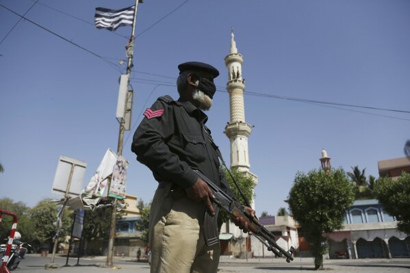 A police officer stands guard outside a mosque during a lockdown to help curb the spread of the coronavirus in Karachi, Pakistan, Friday, March, 3, 2020. Some mosques were allowed to remain open in Pakistan on Friday, the Muslim sabbath when adherents gather for weekly prayers, even as the coronavirus pandemic spread and much of the country had shut down. (AP Photo/Fareed Khan)