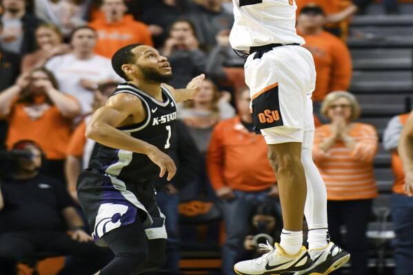 Oklahoma State guard Avery Anderson III (0) takes a shot over Kansas State guard Markquis Nowell (1) during the final minutes of overtime at an NCAA college basketball game Saturday, Feb. 19, 2022, in Stillwater, Okla. Oklahoma State defeated Kansas State 82-79 in overtime. (AP Photo/Brody Schmidt)