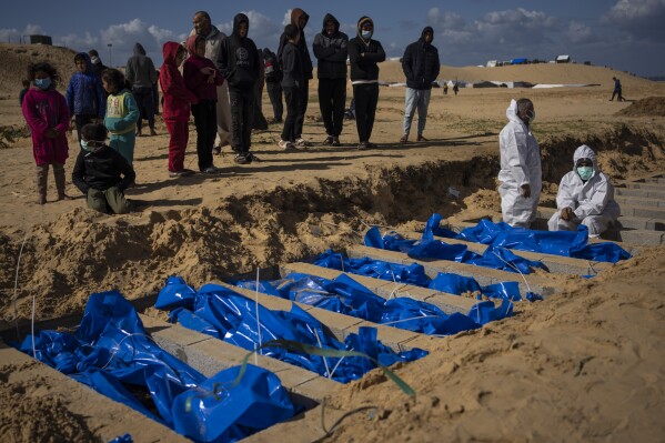 Palestinians bury the bodies of people who were killed in fighting with Israel and returned to Gaza by the Israeli military, during a mass funeral in Rafah, Gaza Strip, Tuesday, Jan. 30, 2024. (APPhoto/Fatima Shbair)