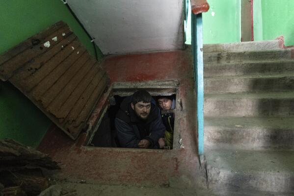 People hide in an improvised bomb shelter in Mariupol, Ukraine, Saturday, March 12, 2022. (AP Photo/Mstyslav Chernov)