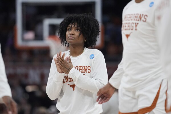 Texas guard Rori Harmon watches teammates warm up for a second-round college basketball game against Alabama in the women's NCAA Tournament in Austin, Texas, Sunday, March 24, 2024. The Texas Longhorns lost standout point guard Rori Harmon to a knee injury in December. Instead of slinking into the shadows of a long recovery for next season, Harmon has been team cheerleader, unofficial assistant coach and invaluable mentor for freshman Madison Booker, who took over the offense in her place and has the No. 1 seed Longhorns roaring into the Sweet 16. (AP Photo/Eric Gay)