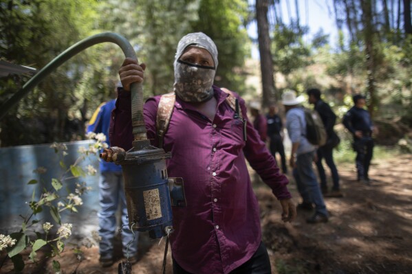 A man shows a pump removed from an unlicensed water intake as his group of residents, farmworkers and small-scale farmers from Villa Madero dismantle illegal water taps in the mountains of Villa Madero, Mexico, Wednesday, April 17, 2024. As a drought in Mexico drags on, angry subsistence farmers have begun taking direct action on thirsty avocado orchards and berry fields of commercial farms that are drying up streams in the mountains west of Mexico City. (AP Photo/Armando Solis)