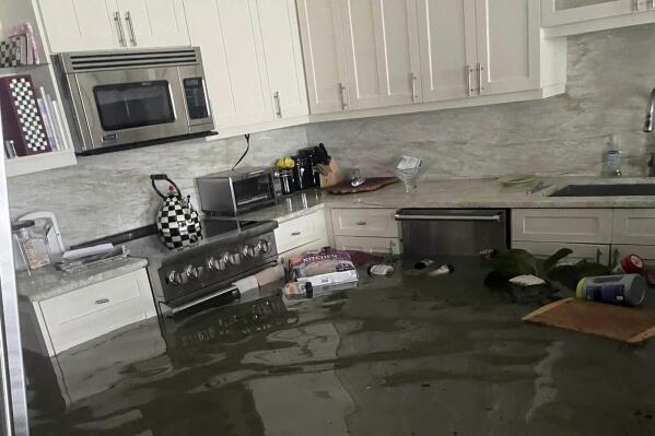 This image provided courtesy of Heather Donlan and posted on social media, shows flooding from Hurricane Ian in her father's home in Naples, Fla. Donlan said her social media post crowdsourced the person she holds responsible for saving her father's life as flooding inundated the 87-year-old's home.  (Courtesy of Heather Donlan via AP)