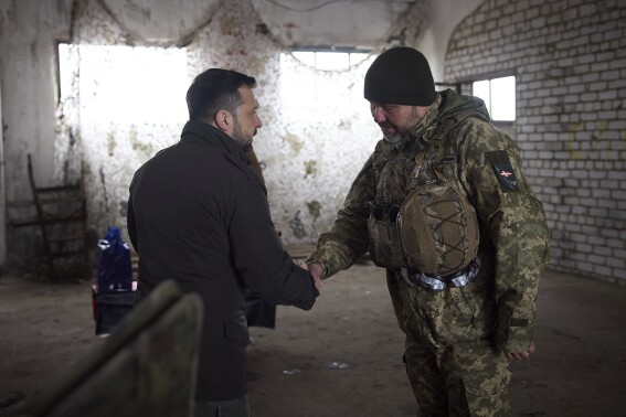 In this photo provided by the Ukrainian Presidential Press Office, Ukrainian President Volodymyr Zelenskyy, left, shakes hand with a soldier during his visit to the front line city of Kupiansk, Kharkiv region, Ukraine, Monday, Feb. 19, 2024. (Ukrainian Presidential Press Office via 番茄直播)