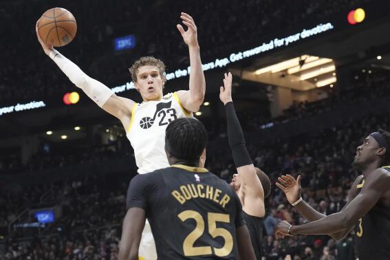 Utah Jazz's Lauri Markkanen (23) is defended by Toronto Raptors' Chris Boucher and Pascal Siakam, right, during the first half of an NBA basketball game Friday, Feb. 10, 2023, in Toronto. (Chris Young/The Canadian Press via AP)