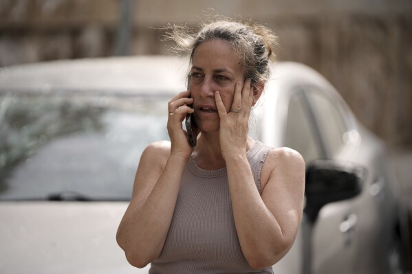 A woman talks on her cellphone at the site where a missile launched from Iran struck in Tel Aviv, Israel, Sunday, June 22, 2025. (AP Photo/Oded Balilty)