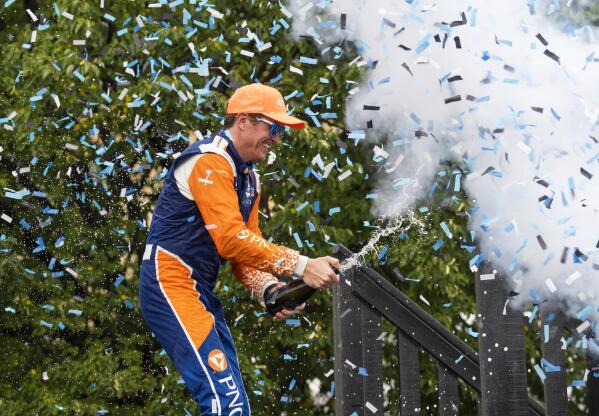 Scott Dixon, of New Zealand, celebrates with champagne in the Winners Circle after winning  an IndyCar auto race in Toronto, Sunday, July 17, 2022. (Mark Blinch/The Canadian Press via AP)