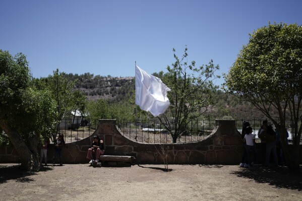 FILE - Peace flags fly on the fence around St. Francis Xavier Parish Church, where two Jesuit priests were killed by a gang leader in 2022. "El Chueco," Cerro Cahui, Mexico, May 12, 2024. When Mexicans vote on June 2, they will be doing so in an increasingly polarized country that continues to suffer staggering levels of violence across the country. (AP Photo/Eduardo Verdugo, File)