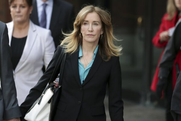 FILE - This April 3, 2019 file photo shows actress Felicity Huffman departing federal court in Boston after facing charges in a nationwide college admissions bribery scandal. Federal prosecutors are asking a judge to sentence “Desperate Housewives” star Felicity Huffman to a month in jail for her role in the sweeping college admissions bribery scandal. (AP Photos/Charles Krupa, File)