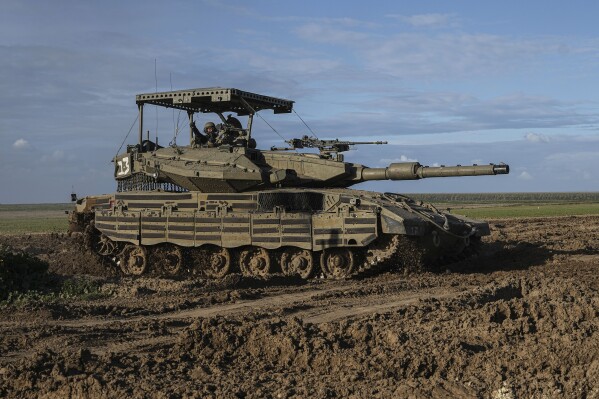 An Israeli soldier waves from a tank on the way back from the Gaza Strip, in southern Israel, near the Gaza border, Thursday, Feb. 1, 2024. (AP Photo/Tsafrir Abayov)