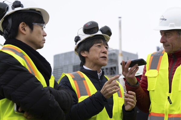 Matsuo Takehiko, center, Japan's Vice Minister for International Affairs at the Ministry of Economy, Trade and Industry (METI), speaks to members of the media before a news conference at the Pump Station 1 on Monday, June 2, 2025, located near Deadhorse, Alaska, on the state's prodigious North Slope. (AP Photo/Jenny Kane)