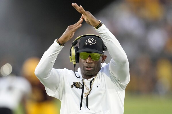 FILE- Colorado head coach Deion Sanders calls for a timeout during the second half of an NCAA college football game against Arizona State, Saturday, Oct. 7, 2023, in Tempe, Ariz. Deion Sanders has put the finishing touches on his Colorado coaching staff, bringing in Robert Livingston as defensive coordinator and sticking with Pat Shurmur to oversee the offense. (AP Photo/Ross D. Franklin, File)