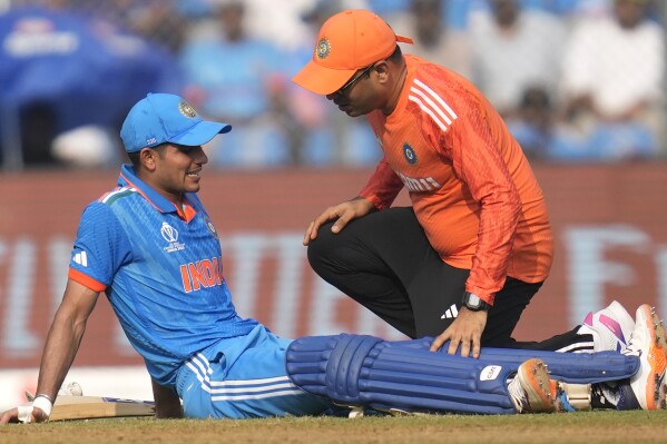 India's Shubman Gill sits on the ground after getting cramps, during the ICC Men's Cricket World Cup first semifinal match between India and New Zealand in Mumbai, India, Wednesday, Nov. 15, 2023. (AP Photo/Rafiq Maqbool)