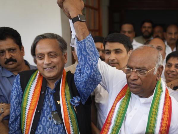 Congress party leader Shashi Taroor, and contender for the party president position, left, raises hands with newly elected president Mallikarjun Kharge in New Delhi, India, Wednesday, Oct. 19, 2022. India's main opposition Congress party elected Kharge as its new president on Wednesday in a contest in which the dominant Nehru-Gandhi dynasty did not compete. (AP Photo/Manish Swarup)